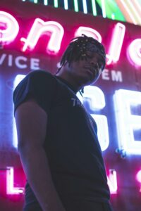 Man Posing With Background Of An Illuminated Signboard