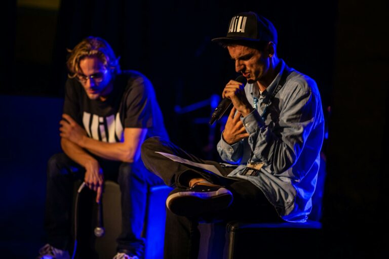 Man Sitting on Ottoman Holding Microphone